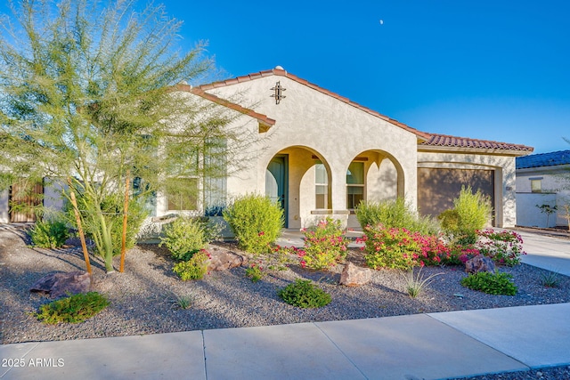 5245 N 205th Ln, Buckeye, AZ 85396 - mediterranean / spanish-style house featuring a tile roof, stucco siding, an attached garage, and driveway