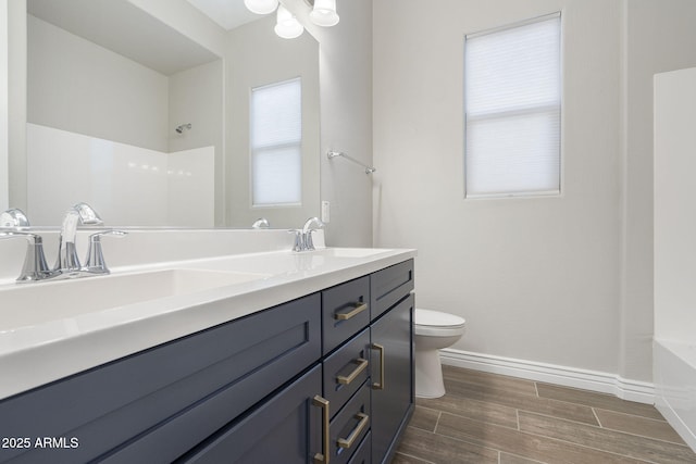 5245 N 205th Ln, Buckeye, AZ 85396 - bathroom with baseboards, double vanity, toilet, wood tiled floor, and a sink