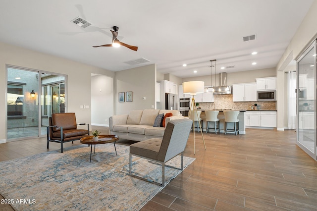 5245 N 205th Ln, Buckeye, AZ 85396 - living room featuring ceiling fan, visible vents, and wood finished floors