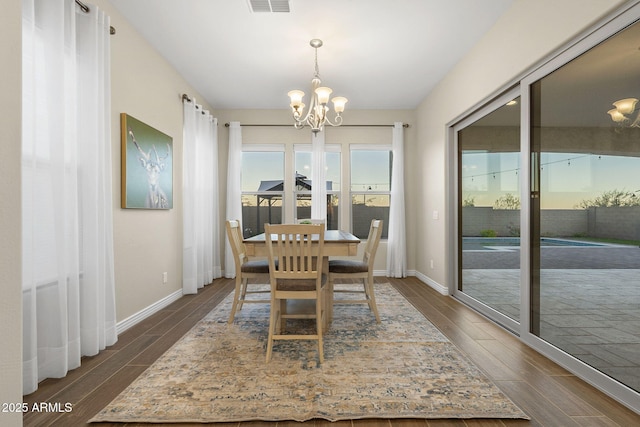 5245 N 205th Ln, Buckeye, AZ 85396 - dining area with baseboards, wood tiled floor, and an inviting chandelier