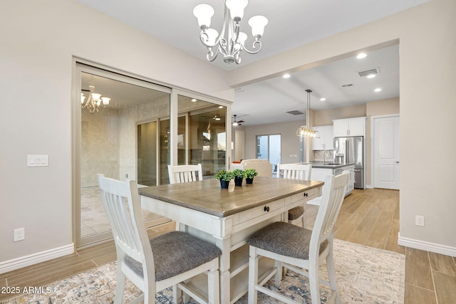 5245 N 205th Ln, Buckeye, AZ 85396 - dining space featuring wood tiled floor, baseboards, and an inviting chandelier