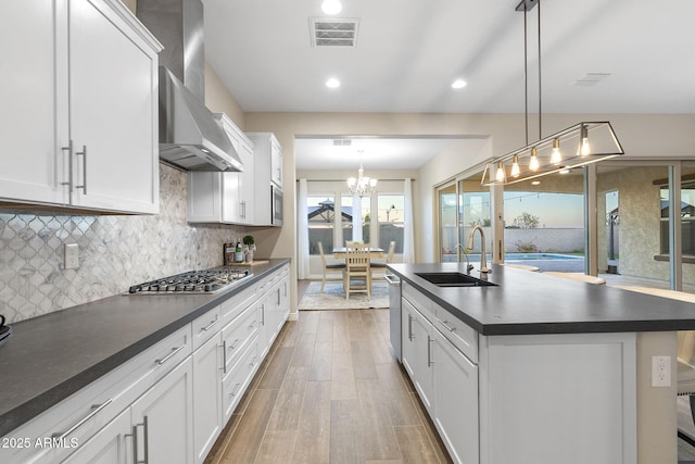 5245 N 205th Ln, Buckeye, AZ 85396 - kitchen featuring visible vents, stainless steel appliances, dark countertops, a sink, and wall chimney range hood
