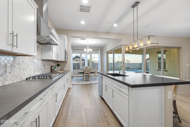 5245 N 205th Ln, Buckeye, AZ 85396 - kitchen with a sink, wall chimney exhaust hood, wood finished floors, appliances with stainless steel finishes, and dark countertops