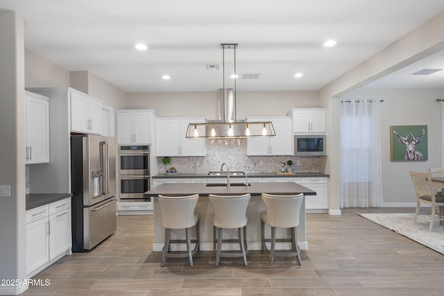 5245 N 205th Ln, Buckeye, AZ 85396 - kitchen with visible vents, dark countertops, tasteful backsplash, appliances with stainless steel finishes, and extractor fan