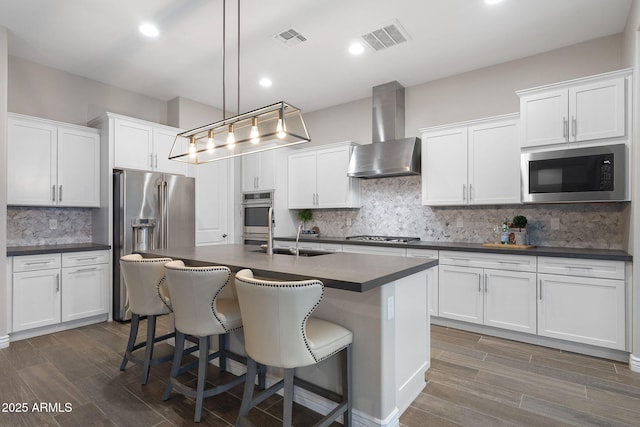 5245 N 205th Ln, Buckeye, AZ 85396 - kitchen with visible vents, stainless steel appliances, wall chimney exhaust hood, and dark countertops