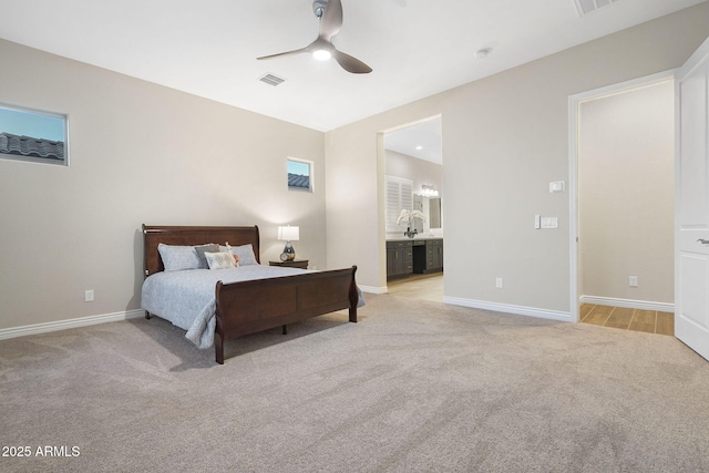 5245 N 205th Ln, Buckeye, AZ 85396 - bedroom with connected bathroom, baseboards, light colored carpet, visible vents, and ceiling fan
