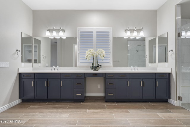 5245 N 205th Ln, Buckeye, AZ 85396 - bathroom featuring wood finish floors, a sink, two vanities, and a tile shower