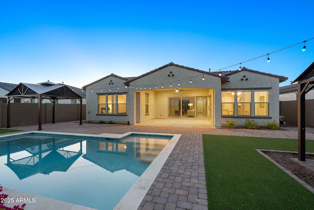 5245 N 205th Ln, Buckeye, AZ 85396 - rear view of property with a fenced backyard, a tile roof, stucco siding, and a patio area