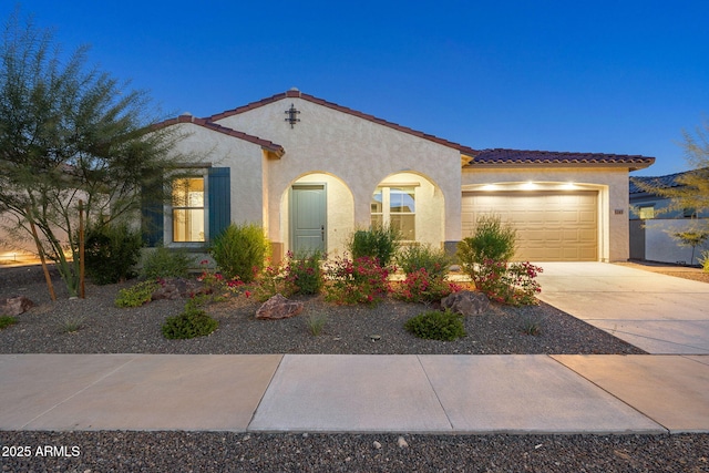 5245 N 205th Ln, Buckeye, AZ 85396 - mediterranean / spanish house featuring stucco siding, an attached garage, a tiled roof, and concrete driveway