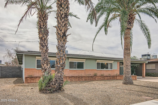 single story home with cooling unit and a carport