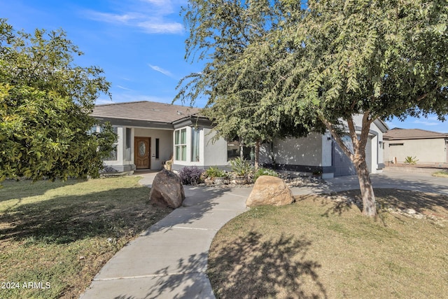 view of front of property featuring a front yard and a garage