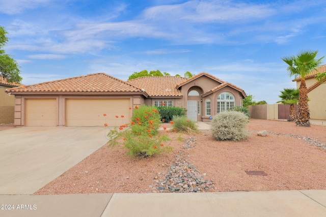 view of front of property featuring a tiled roof, stucco siding, an attached garage, and concrete driveway