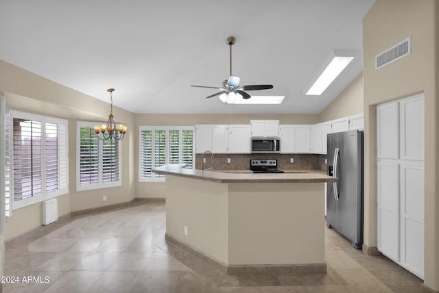 kitchen with visible vents, light countertops, decorative backsplash, vaulted ceiling with skylight, and stainless steel appliances