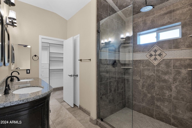 bathroom featuring double vanity, walk in shower, tile patterned floors, and a sink