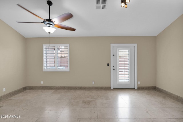 empty room featuring baseboards, visible vents, and ceiling fan