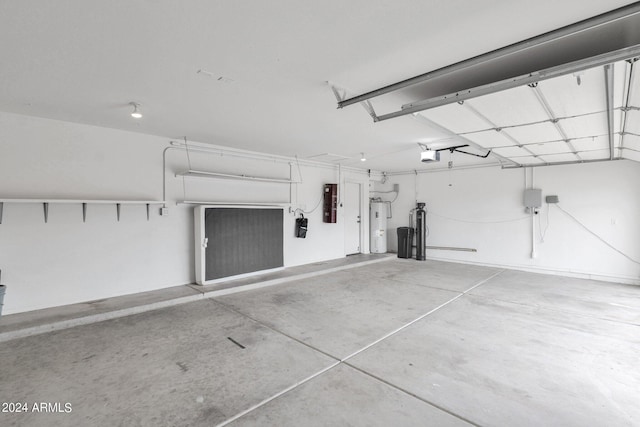 garage featuring electric panel, a garage door opener, and water heater