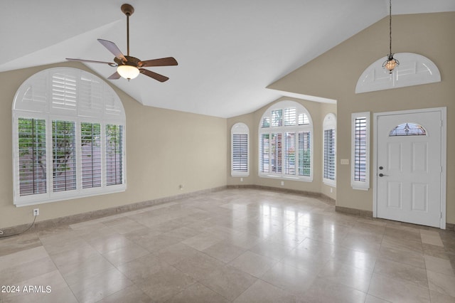 entryway featuring light tile patterned floors, baseboards, high vaulted ceiling, and ceiling fan