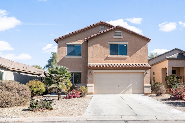 mediterranean / spanish house with a garage, concrete driveway, a tile roof, and stucco siding