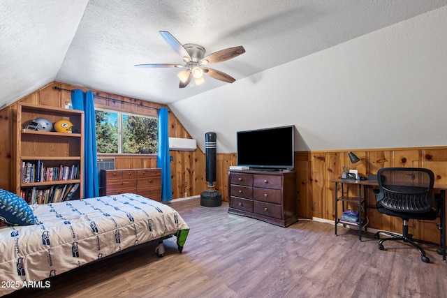 3219 N Pinewood Dr, Pine, AZ 85544 - bedroom with wooden walls, wood finished floors, lofted ceiling, a textured ceiling, and a ceiling fan