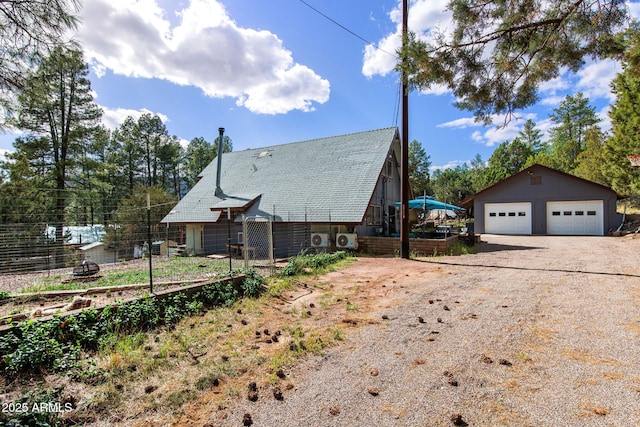 3219 N Pinewood Dr, Pine, AZ 85544 - back of house with a detached garage, an outdoor structure, roof with shingles, and ac unit