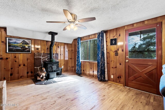 3219 N Pinewood Dr, Pine, AZ 85544 - entryway with a wood stove, hardwood / wood-style floors, a ceiling fan, wood walls, and healthy amount of natural light