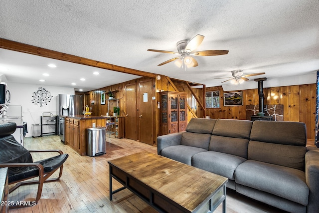 3219 N Pinewood Dr, Pine, AZ 85544 - living area featuring wood walls, a ceiling fan, a wood stove, recessed lighting, and a textured ceiling
