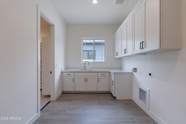 washroom with electric dryer hookup, cabinets, sink, and hookup for a washing machine