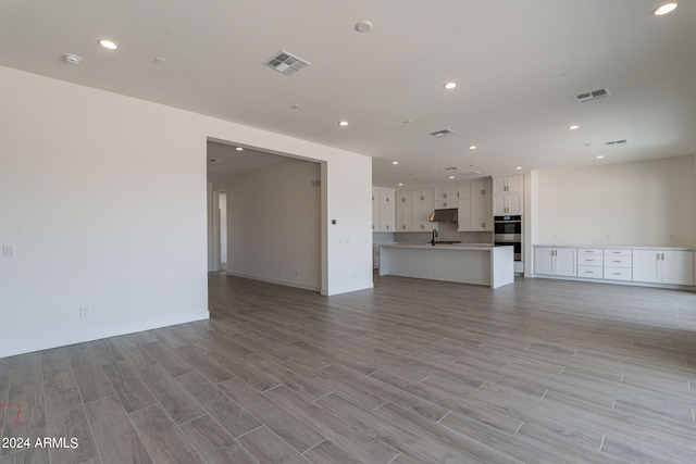 unfurnished living room featuring sink