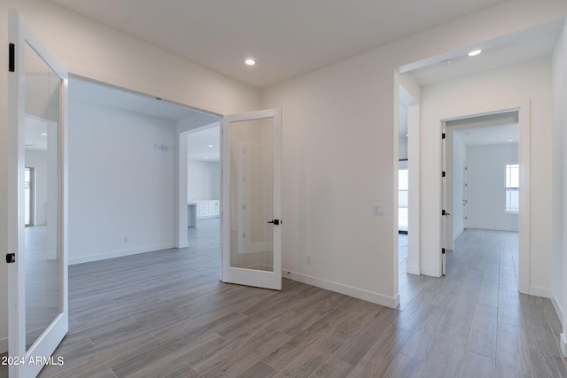 hall with french doors and light hardwood / wood-style floors