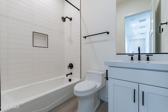 full bathroom with toilet, vanity, tiled shower / bath combo, and hardwood / wood-style flooring