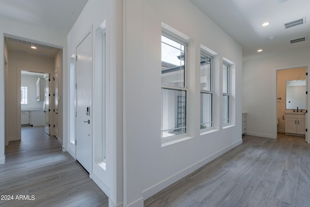 hallway with light hardwood / wood-style floors