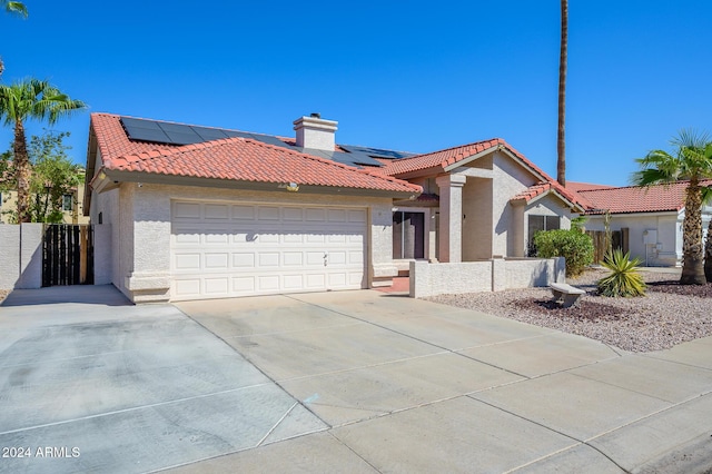 view of front of home with solar panels and a garage