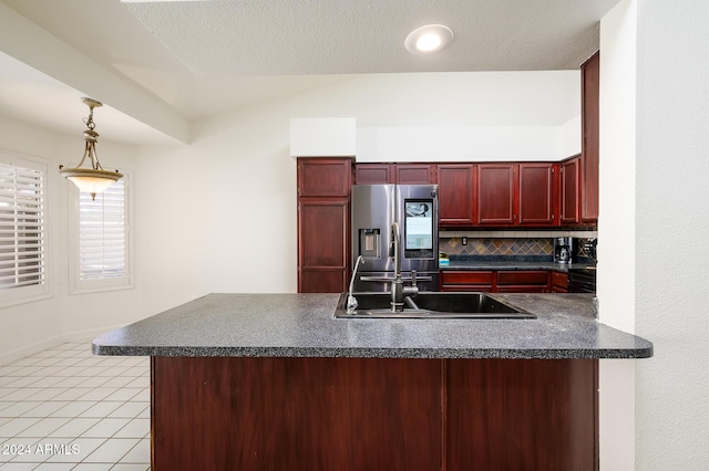 kitchen with pendant lighting, sink, kitchen peninsula, tasteful backsplash, and stainless steel fridge with ice dispenser