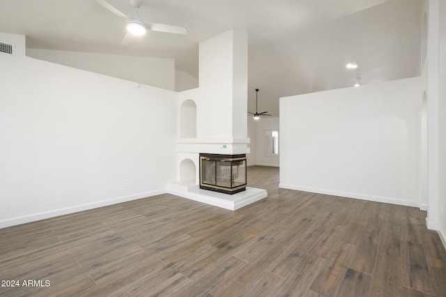 unfurnished living room featuring a multi sided fireplace, hardwood / wood-style floors, vaulted ceiling, and ceiling fan