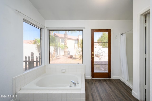 bathroom featuring shower with separate bathtub, hardwood / wood-style flooring, and lofted ceiling