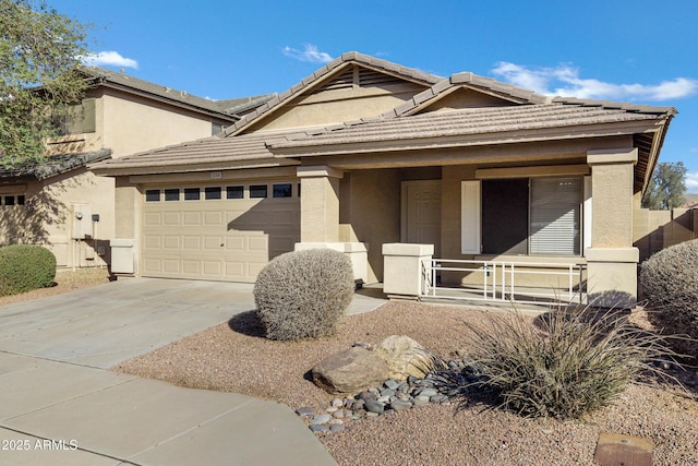 view of front of home with a garage, a tile roof, concrete driveway, and stucco siding