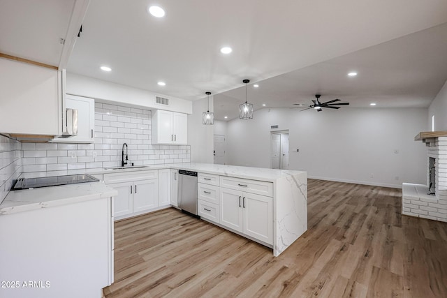 kitchen with light stone countertops, kitchen peninsula, white cabinetry, and stainless steel dishwasher