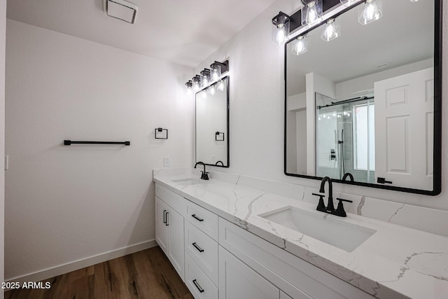 bathroom with hardwood / wood-style floors, vanity, and a shower with shower door