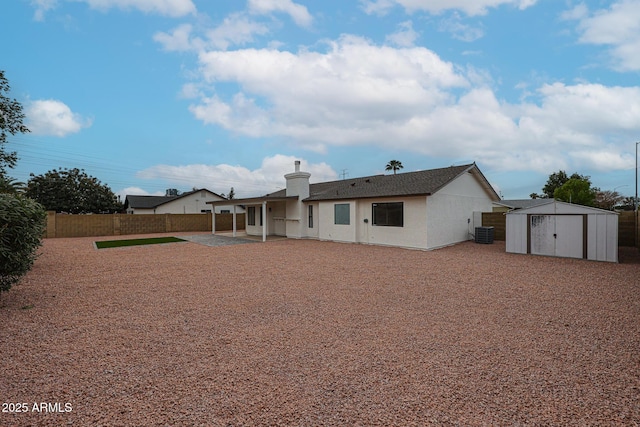back of property with a storage unit, a patio area, and central air condition unit