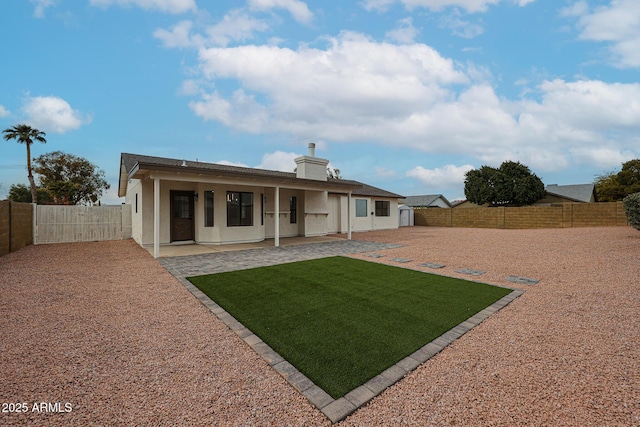 back of house with a patio area and a lawn