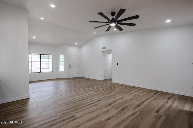 interior space with ceiling fan, lofted ceiling, and light wood-type flooring