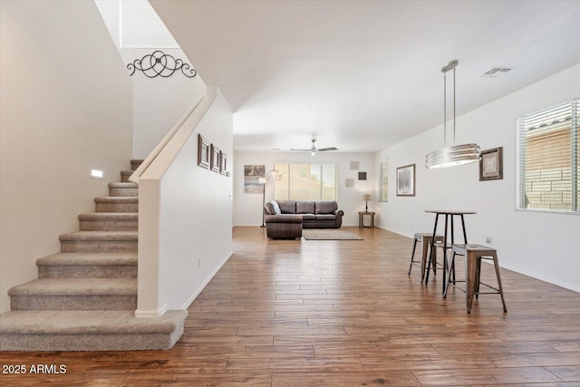 10417 W Alyssa Ln, Peoria, AZ 85383 - living area with wood finished floors, ceiling fan, visible vents, and stairs