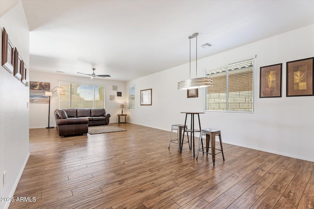 10417 W Alyssa Ln, Peoria, AZ 85383 - living room featuring visible vents, ceiling fan, wood finished floors, and baseboards