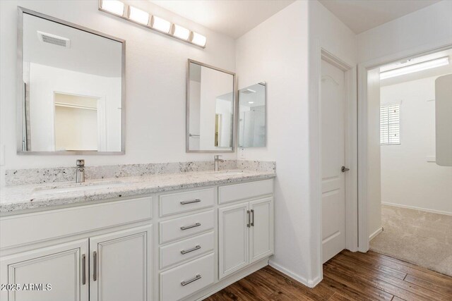 10417 W Alyssa Ln, Peoria, AZ 85383 - full bathroom featuring baseboards, double vanity, visible vents, a sink, and wood finished floors