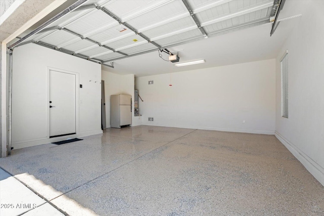 10417 W Alyssa Ln, Peoria, AZ 85383 - garage with baseboards, freestanding refrigerator, and a garage door opener