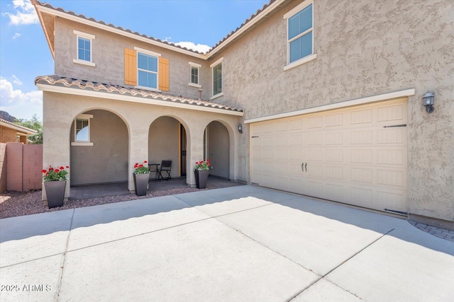 10417 W Alyssa Ln, Peoria, AZ 85383 - mediterranean / spanish house with stucco siding, a porch, a tile roof, a garage, and driveway