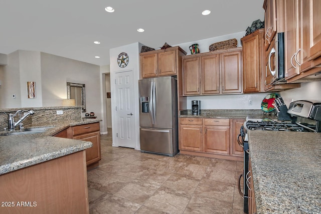 kitchen with light stone counters, stainless steel appliances, and sink