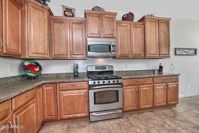 kitchen with stainless steel appliances and dark stone countertops