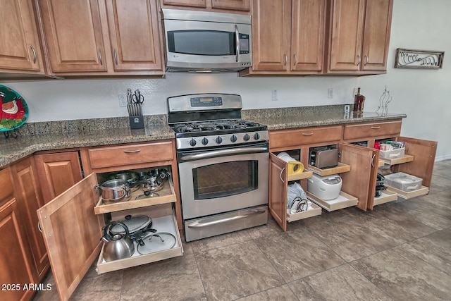 kitchen featuring stainless steel appliances and dark stone counters