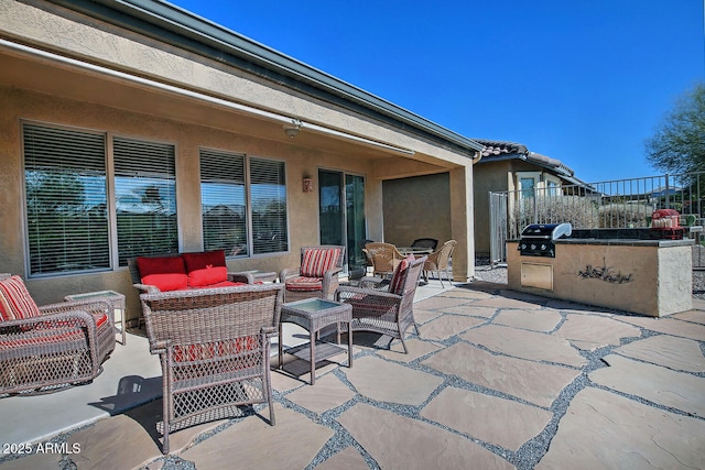 view of patio / terrace featuring a grill, an outdoor hangout area, and exterior kitchen